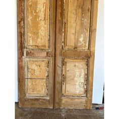 an old wooden armoire with peeling paint on it's doors and bottom panel