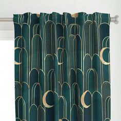 a green curtain with an art deco design on the top and bottom, hanging in front of a window