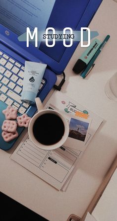 a laptop computer sitting on top of a white desk next to a cup of coffee