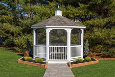 a white gazebo sitting on top of a lush green field