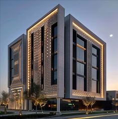 a large building with lights on the side of it's face and windows at night