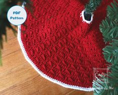 a red knitted christmas ornament hanging from a tree branch with the text free pattern