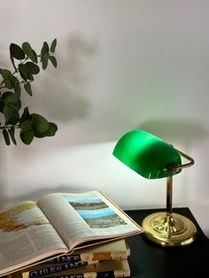 a green lamp sitting on top of a table next to books