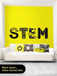 a living room with yellow walls and black decals