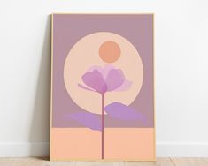 a purple flower sitting on top of a wooden floor in front of a white wall