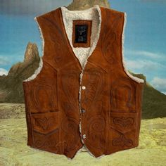 Vintage / Handmade - Brown Suede Wool Trimmed Vest - Antique Western Vintage Handmade Brown Soft Leather Suede Vest With Wool Trim And Hand Engraved Design Beautiful Engraved Western Design On Front And Back 2 Side Pockets On Front + Snaps Closed Never Worn Antique Vintage Circa ~ 1975 Soft Suede + White Wool There Is No Size Label - I Have The Measurements Listed Below! I Haven’t Used A Leather Cleaner/Conditioner On It, So The Color Is Slightly Faded, Other Than That There Are No Flaws, Rips, Brown Winter Outerwear For Rodeo, Fitted Western Vest Outerwear, Fitted Western Style Vest Outerwear, Fitted Western Style Outerwear Vest, Vintage Winter Vest Outerwear, Fitted Western Vest For Winter, Fitted Western Style Winter Vest, Fitted Western Brown Outerwear, Fitted Brown Western Outerwear