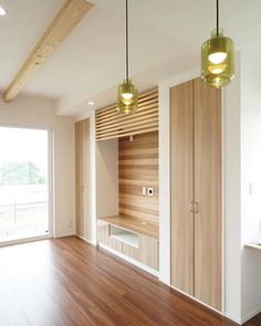 an empty room with wood flooring and two lights hanging from the ceiling above it