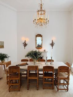 a dining room table with chairs and a chandelier