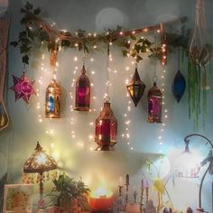 many lights are hanging on the wall above a table with candles and other decorations around it