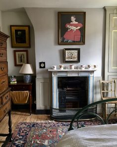 a bedroom with a fireplace and pictures on the wall