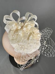 Cute mini cream bridal fascinator.  Adorned with tiny roses. Appliqués, pearl brooch, ribbon and veiling.  Attached with large clip Elegant Handmade Flower Hair Accessories For Formal Events, Elegant Handmade Flower Hair Accessories For Formal Occasions, Elegant Formal Headpiece With Handmade Flowers, Elegant Wedding Headpiece With Flower Decoration, Elegant Floral Wedding Headpieces, Elegant Flower Hair Accessories For Wedding, Elegant Wedding Hair Accessories With Flower Decoration, Elegant Flower Wedding Hair Accessories, Elegant Fascinator For Ceremony With Handmade Flowers