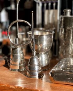 an assortment of silver cups and saucers on a table