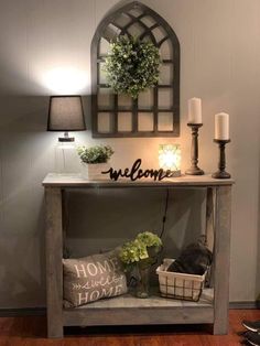 a table with a welcome sign on it and some candles in front of the table