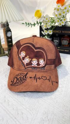 a baseball cap with the words dad and three children on it sitting on a table