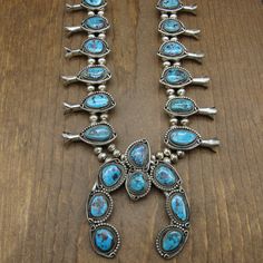 "Sterling silver and turquoise squash blossom necklace. This necklace is 27\" long. The naja is 3 1/2\" tall x 3\" wide. There are 8 turquoise stones on the naja. It is signed Tony Garcia on the back. The silver beads are 8mm in diameter. Each side has 6 blossoms which are from 1 5/8 to 1 3/4\" long. The bezel set stones are surrounded by twisted wire rope. One side has a silver bead edge. On the other side a silver wire with a loop on the top and bottom. The stones in the two blossoms closest t Southwestern Blue Jewelry For Western-themed Events, Blue Western Style Jewelry With Inlay, Western Blue Jewelry For Western-themed Events, Turquoise Squash Blossom, Squash Blossom Necklace, Silver Eagles, Squash Blossom, Twisted Wire, Southwestern Jewelry