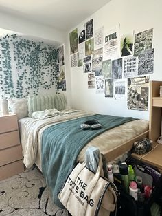 a bed room with a neatly made bed and lots of pictures on the wall