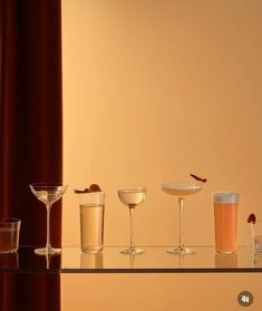 there are many different types of drinks on the glass table in front of the window