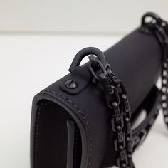 a black leather case with chains hanging from it's front end and the back side