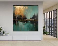 a large painting hanging on the wall in a living room next to a plant filled with potted plants