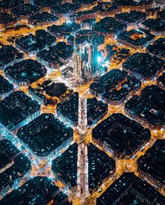 an aerial view of a city at night with lots of lights and buildings in the background