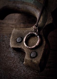 -------  This solid copper ring is hand-forged. Small circles and notches reminiscent of prehistoric finds are worked into the surface. These small marks vary slightly on each pendant and make it unique. To give the piece more depth, it is given an antique patina. The handmade eyelet is soldered firmly so that the pendant remains stable in the future.  -------  The pendant is 28 mm wide and 39 mm high with the eyelet & comes with a brown cotton ribbon. -------  The shape of the circle represents Small Ornaments, Cotton Ribbon, Copper Ring, Rustic Jewelry, Small Circle, Copper Pendant, Copper Rings, Copper Pendants, Lucky Charm