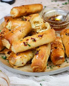 a plate full of bread rolls and dipping sauce