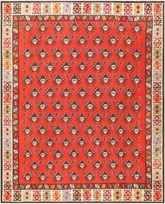 an orange and red rug with many different designs on the border, including flowers and leaves