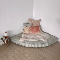 a round bed sitting on top of a hard wood floor next to a white wall