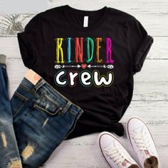 a t - shirt that says kinder crew on it next to jeans and sneakers