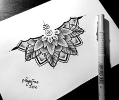 a drawing of a flower on paper next to a pen