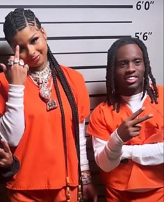 two people in orange prison uniforms standing next to each other and pointing fingers up at the camera