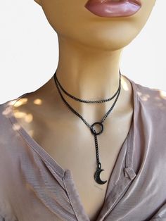 This is a bold and edgy blackened steel Gothic moon minimalist Lariat Necklace choker with a great Pagan witch aesthetic. This is a minimalistic, small curb chain with .5 inch crescent moon charm. The minimalist design gives it a trendy and stylish feel, while the black steel gives it a touch of gothic Punk edge. Please understand that this necklace is not designed for play, it is ornamental. ALSO IN STEEL AND GOLD! STEEL: https://shieldmaidensjewelry.etsy.com/listing/1804896523 GOLD: https://sh Black Stainless Steel Choker, Black Metal Jewelry With Moon Charm, Edgy Gunmetal Jewelry With Adjustable Fit, Black Metal Moon Shaped Jewelry, Adjustable Gunmetal Edgy Jewelry, Black Metal Moon-shaped Jewelry, Gunmetal Minimalist Adjustable Jewelry, Gunmetal Adjustable Minimalist Jewelry, Minimalist Gunmetal Metal Jewelry