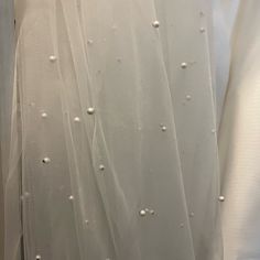 the back of a wedding dress with pearls on it