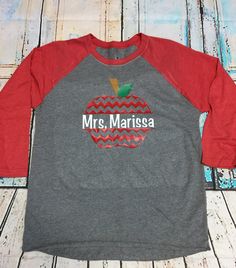 This is perfect for that special teacher in your life. This is a raglan, or baseball shirt as most refer to them. The shirt here is gray with red sleeves which really compliments the red apple. The vinyl colors can be changed also to suit your preferences. Thank you so much for shopping, it is greatly appreciated. If you have any questions or concerns, please feel free to ask. I am happy to help. Customizable School Spirit Red T-shirt, Red T-shirt For School Spirit In Fall, Customizable Red Long Sleeve T-shirt, Customizable Long Sleeve Red T-shirt, Baseball Shirt, Toddler Tees, Baseball Shirts, Vinyl Colors, Red Apple