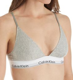 Soft cotton stretch bralette with elastic logo band. Made of cotton, modal, polyamide, polyester and elastane. Wireless, cotton-blend cups are lined with same fabric with vertical darts for shape. Deep V-neckline has covered elastic edge. Soft sewn-on Calvin Klein elastic underband. Sides and back are stretch cotton with covered elastic at top and underband at bottom. Narrow, center pull straps are soft restricted stretch elastic that fully adjusts at back with coated metal hardware. Convertible Calvin Klein Long Sleeve Bra, Ck Grey Bra, Seamless Cotton Bra, Spring Cotton Sports Bra With Built-in Bra, Stretch Cotton Bra With Light Support, Stretch Cotton Bra With Removable Pads, Cotton Bra With Removable Pads And Stretch Fit, Cotton Stretch Bra With Removable Pads, Cotton Fitted Bra With Removable Pads