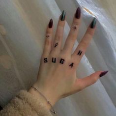 a woman's hand with tattoos on it and the word supa written in black ink