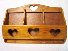 a wooden shelf with three heart shaped holes in the front and two on the back