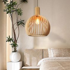 a white bed sitting next to a plant in a bedroom