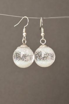 Snow globe earrings Glass globe Flying Snowflakes winter jewelry Christmas gift for women #NewJewelleryStory #Snow #globe #earrings Length: 1/2 Inches; Drop length: 1 Inches; Width: 1/2 InchesSnow globe earrings.Glass globe filled with water and and sequins.It is winter with falling snowflakes.These earrings are a wonderful Christmas present for mom and friends.Glass Sphere 14 mm ( 1/2")Length Drop Earrings: 25mm ( 1" ) Round Winter Jewelry Gift, Round Jewelry Gift For Winter, Sparkling Clear Round Jewelry, White Round Christmas Jewelry, Glitter Round Jewelry As Gift, Round Glitter Jewelry As Gift, Round Glitter Jewelry For Gifts, Silver Glitter Round Earrings, Glitter Jewelry Gift