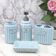 a blue bathroom set with soap dispenser and toothbrush holder