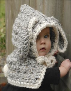 a baby wearing a crocheted bear hat and scarf