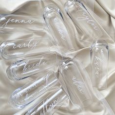 six wine glasses with names on them sitting on a bed