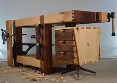 a workbench made out of wood with tools on the bottom and one drawer open