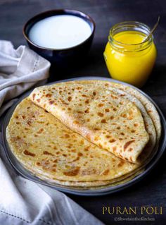 three flat breads on a plate next to a cup of milk and a glass of orange juice