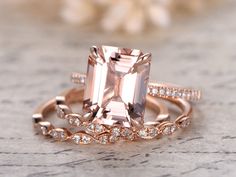 an engagement ring set with a large pink morganite surrounded by smaller white diamond bands