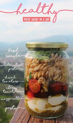 a jar filled with pasta salad in a jar on top of a wooden table next to the words healthy