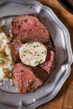 steak, mashed potatoes and green onions on a plate