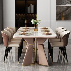 a dining table with chairs around it and a vase filled with flowers on the table