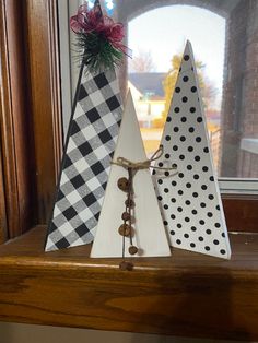 three wooden christmas trees sitting on top of a window sill