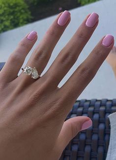 a woman's hand with pink manicures and a diamond ring